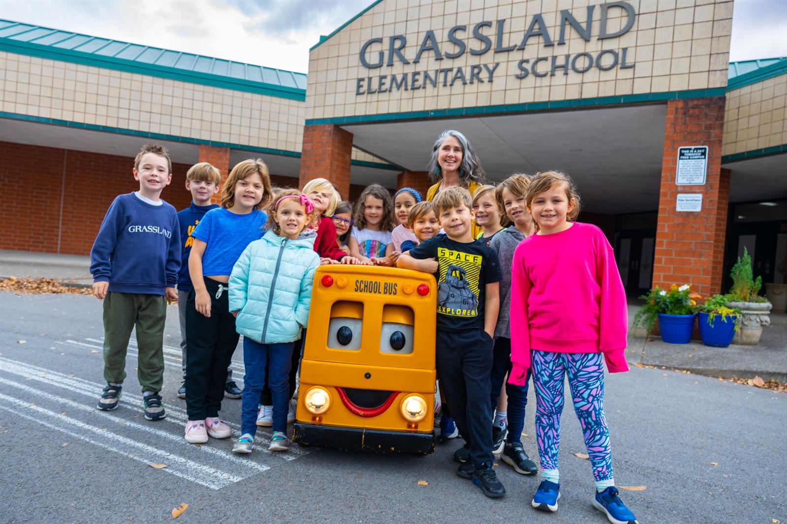 students and teacher with bus mascot in front of GES